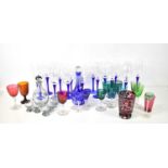 A group of various coloured glasswares, including a number of blue twist stem champagne flutes and