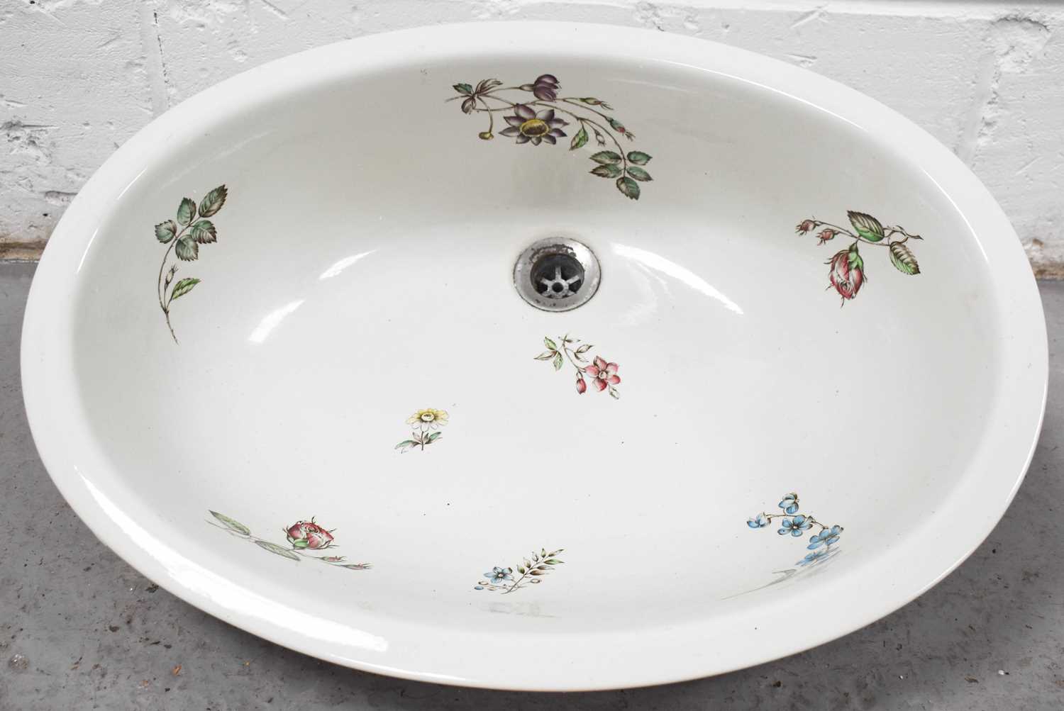 A porcelain sink of oval form, decorated with sprigs of spring flowers, by Johnson brothers, Stoke