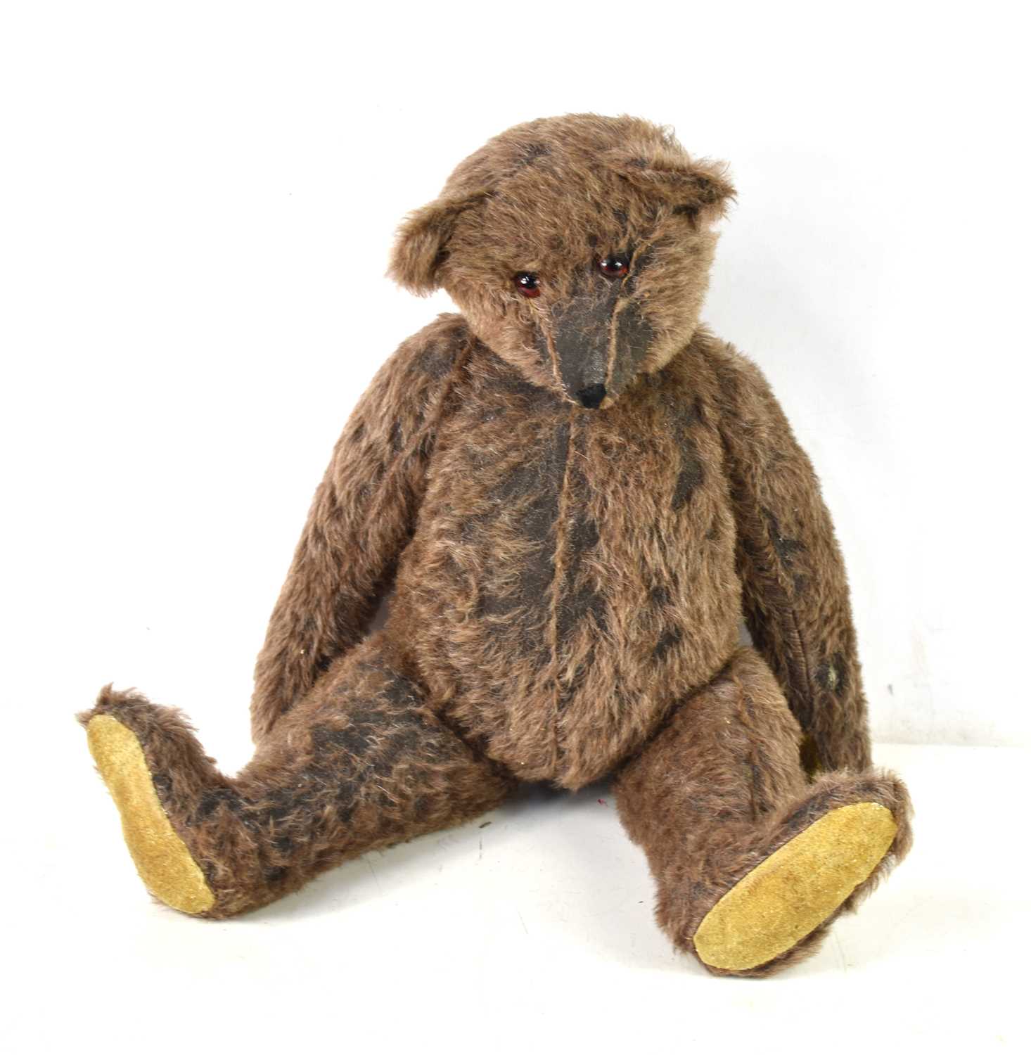 A straw filled teddy bear, in the style of Steiff, brown mohair body, swivel head and jointed at