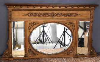 An ornately Classical style overmantle mirror, of triform, with central oval mirror with garlanded