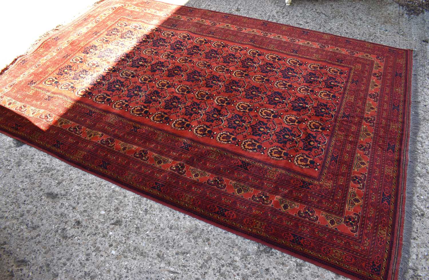 A Middle eastern red ground rug decorated with stylised floral motifs and stylised borders and - Image 2 of 4