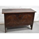 A small 17th century oak coffer, the planked top above a lunette carved front panel and V cut end