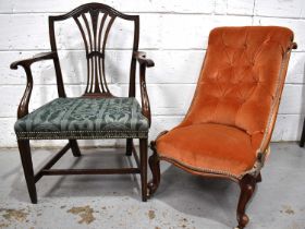 A Victorian mahogany nursing chair with orange velor upholstered button back raised on ceramic