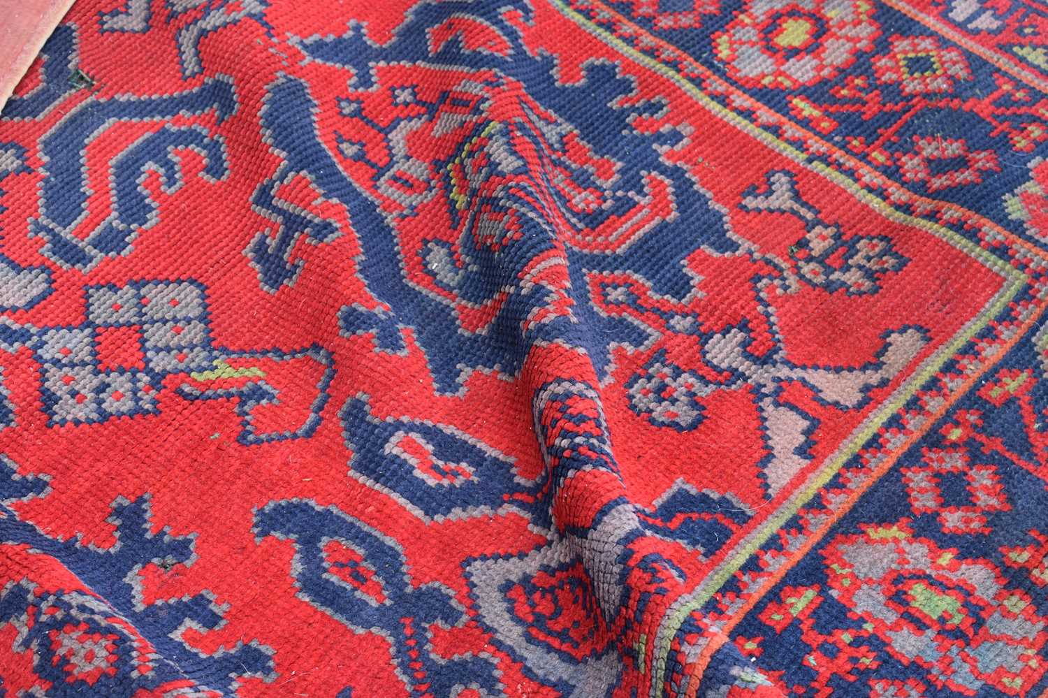 Two antique wool rugs likely Middle Eastern origin both with red ground and stylised motifs and - Image 8 of 13