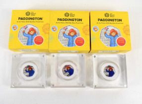 A group of three Royal Mint silver proof Paddington 50p coins, each set in acrylic in original box
