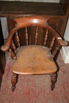 Antique smokers bowl style chair with spindle back, saddle seat, raised on turned baluster supports.
