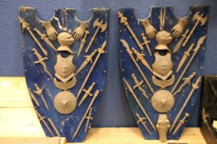 Two blue baize shield plaques decorated with cast metal miniature arms including a suit of armour,