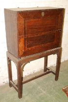 Antique oak campaign cabinet on stand, the fall front with fully fitted interior including
