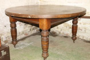 Victorian mahogany extending dining table, raised on turned supports, capped by castors.