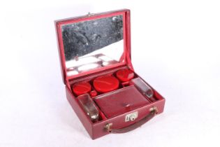 Art Deco style red leather hinge top vanity case, the lid with mirror inset and red plastic topped