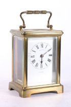 French brass carriage clock with white enamel dial with Roman numeral chapter ring, retailed by