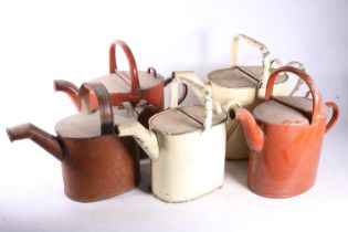 Five painted metal watering cans, the largest 29cm tall