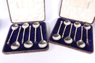 Two cased sets of six white metal serving spoons with apostle terminals.