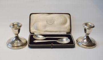 Pair of silver dwarf candlesticks, loaded, and a pair of silver spoons, cased.