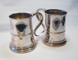 Pair of mid-18th century plated quart mugs with moulded bands, on similar spreading bases with inset