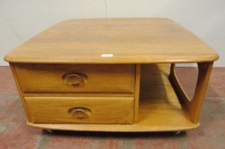 Ercol blonde elm Pandora's Box coffee table of square form with two drawers to one end, flanked by