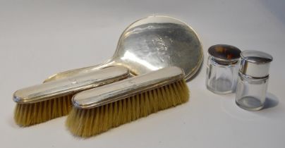 Silver hand mirror, a pair of clothes brushes and two toilet jars.