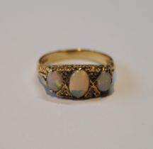 Opal three-stone ring of Edwardian style with diamond chips, in 9ct gold, size N½, 4.3g gross.