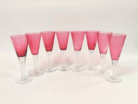 Set of eight cranberry cocktail glasses, each with large trumpet shaped bowl on clear glass stem and