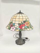 Tiffany style stained glass table lamp with floral motif shade on moulded base. Height 63cm Shade