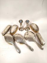 Pair of silver candlesticks and a pair of similarly mounted brushes and five toilet items.