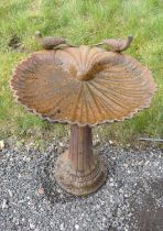 Antique cast iron bird bath decorated with two doves above scallop bowl on a reeded column. 67cms.