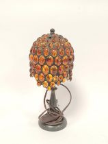 Tiffany style table lamp, the shade with overall inset amber beads, on knopped stem and circular