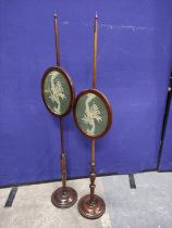 Two 19th century pole screens with turned columns and finials with oval fabric panels on turned