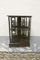 Early 20th century mahogany revolving bookcase of small proportions with open pierced divisions on