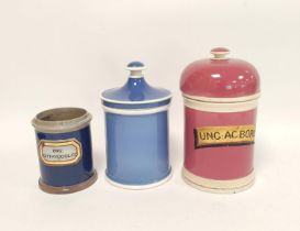 Two 19th century ceramic chemist jars with covers in blue and pink glaze, named to the pink jar,