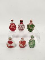 Group of six Chinese glass snuff bottles, mainly Peking examples overlaid with birds and foliage,