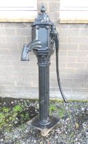 Antique cast iron Victorian black painted water pump on reeded column with foliate decoaration.