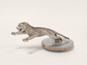 Jaguar car mascot circa 1920s modelled as a leaping white metal jaguar, on a chrome patina disc