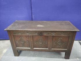 Antique oak coffer with triple panelled front, with carved quatrefoils and frieze, the cover