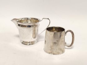 Silver cream jug with concave band and a christening mug, 162g. 5oz. (2)