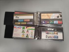 Two albums of c2000s British mint presentation packs postage stamp sets comprising of 173 first