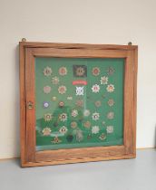 Framed collection of British military cap badges mostly Victorian and WW1 and relating to Scottish