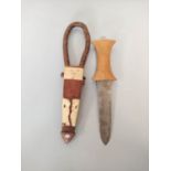 A Sudanese arm knife with tapering straight blade and carved wooden hilt. Contained in tooled