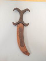 A Sudanese Beja dagger with sharply curving blade and characteristic X-form carved wooden handle