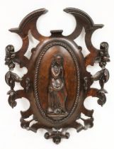 Victorian carved wooden plaque, the oval central reserve with raised classical maiden design, within