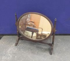 Mahogany toilet mirror with oval plate upon turned supports and shaped feet, 19½"