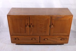 Ercol Windsor model 468 elm sideboard, c1960s, having a twin door cupboard alongside a single door