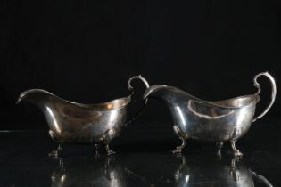 Pair of George VI silver sauce boats, gadrooned border with C scroll handles on three shell pad