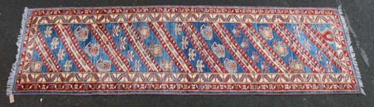 Kazak style runner, polychrome geometric motifs and stripes on a blue ground within conforming