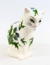 Wemyss Griselda Hill pottery cat figurine with green glass eyes, body decorated with thistles,