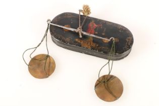 Georgian pocket balance scales, in black japanned metal case, the front cover decorated in enamels