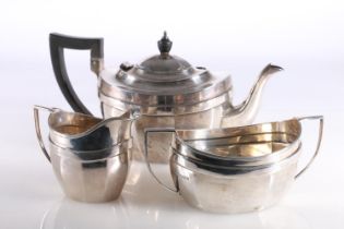 George V hallmarked silver three-piece tea set, the faceted shaped teapot with ebony finial and