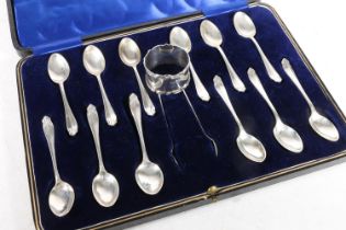 Cased set of twelve George V silver teaspoons and sugar tongs in fitted blue velvet interior case,