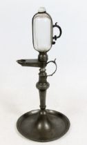 Continental pewter whale oil lamp clock, 19th century, the glass reservoir enclosed within pewter