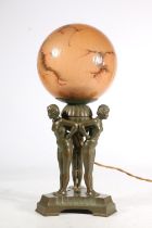 An Art Deco patinated spelter table lamp, c1930s, the marbled glass globe shade supported by three